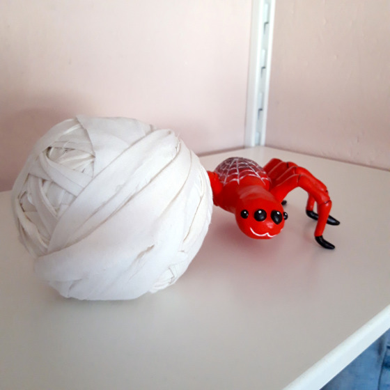 Spindeln tillsammans med en stor vit boll av tråd.