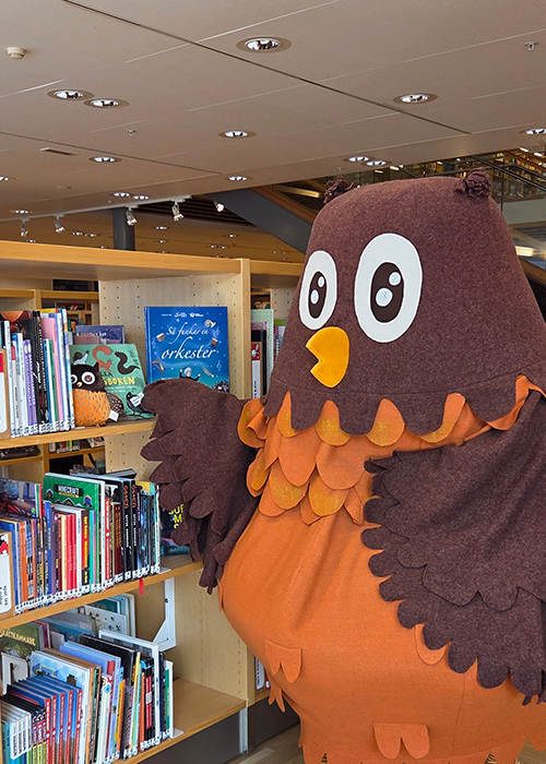 Polarugglan på biblioteket vid bokhyllorna