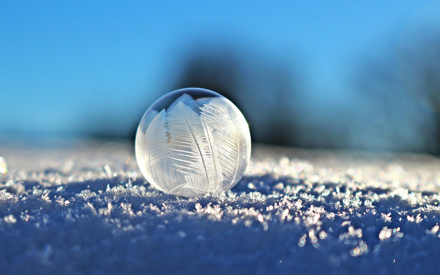 En såpbubbla i snö med iskristaller på.