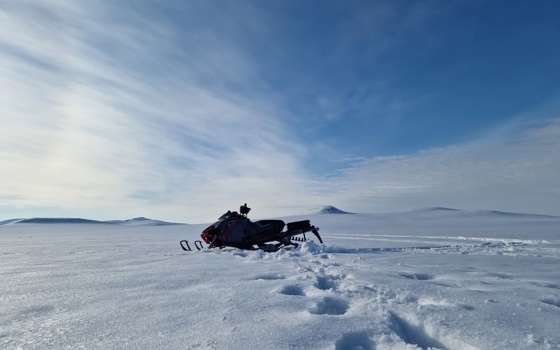 Skoter på snötäckt sjö.