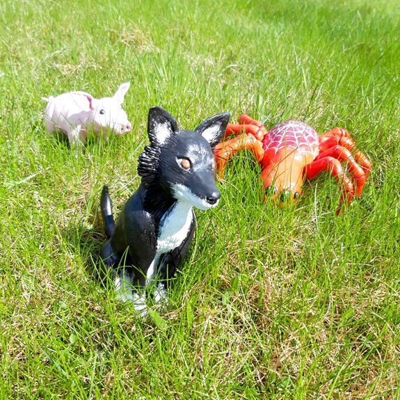 Grisen, hunden och spindeln ute i gräset.