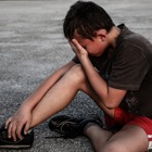 Barn som sitter på gruset och är ledsen. 