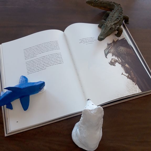 Hajen, Fjällräven och Krokodilen läser en bok tillsammans.
