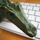 Krokodilen sitter på ett tangentbord.