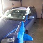 Hajen framför en blå bil.