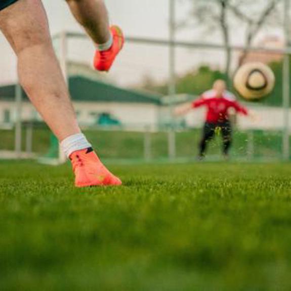 Sparkar fotboll mot mål.