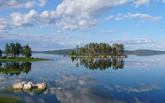 En sjö med öar och berg i bakgrunden.
