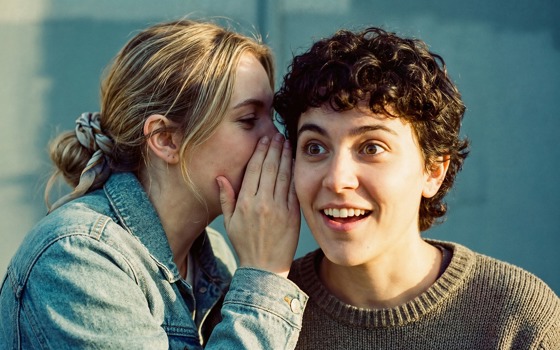 En tjej som viskar något till en kille.