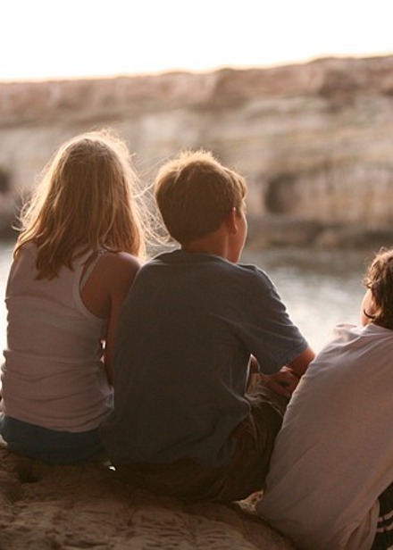 Fyra barn sitter på klippa.