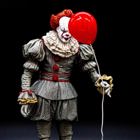 Clown som håller i en röd ballong.