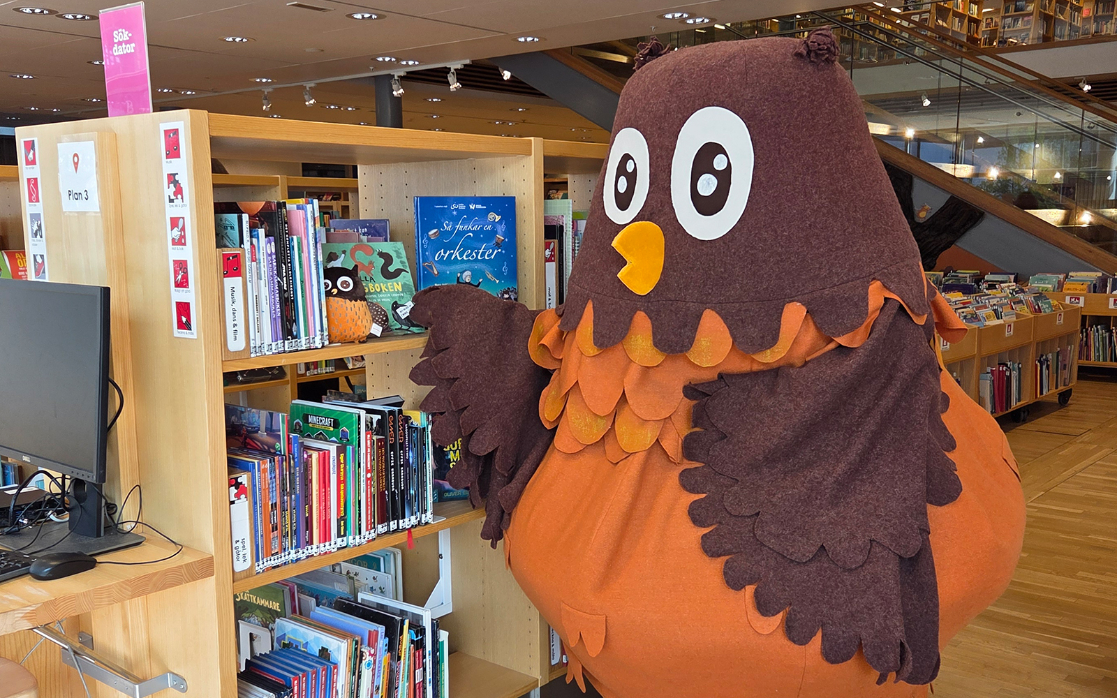 Polarugglan på biblioteket vid bokhyllor