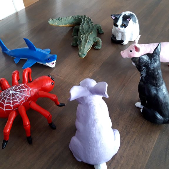 Spindeln, hajen, krokodilen, katten, grisen, hunden och kaninen står i en cirkel.