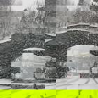 Det snör mycket, en bil kör under en bro.