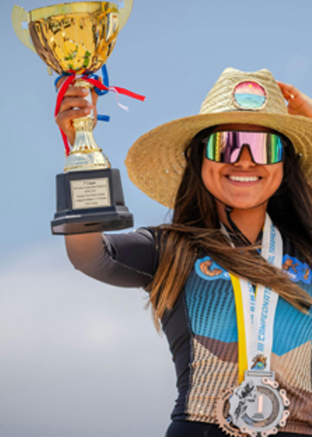 Kvinna som håller upp en guldpokal.