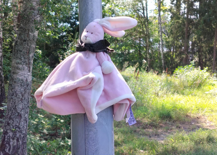 En rosa kaninsnutte som är fastknytt på en lyktstolpe.