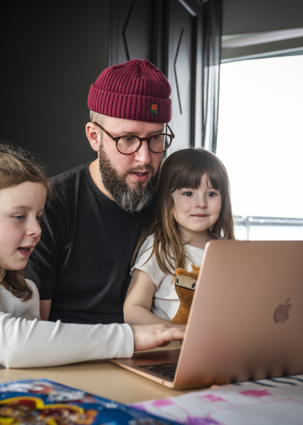 Pappa med barn vid dator.