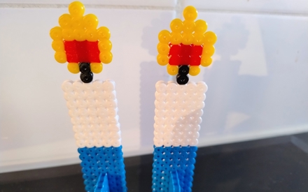 Kaksi sinivalkoista kynttilää askarteltu helmistä.