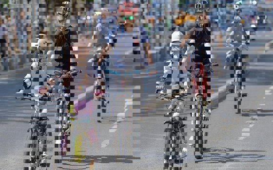 Barn och vuxen som cyklar på en väg.
