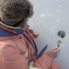 En som sitter och pimplar.