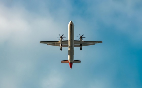 Ett flygplan som man ser underifrån som flyger i luften.