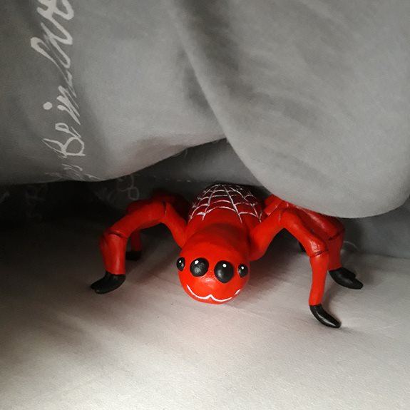 Spindeln gömmer sig under ett täcke.